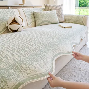Minimalist green textured chenille sofa cover with scalloped edge for living room decor.