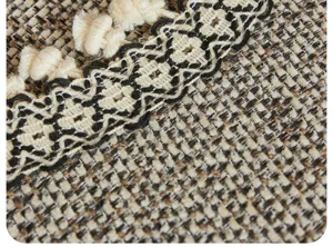Gros plan du tissu de coussin de canapé tissé texturé avec franges et motif géométrique