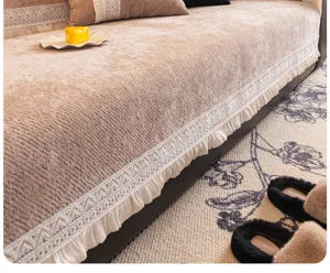 Vue détaillée d'un coussin de canapé en chenille luxueux avec fine bordure en dentelle.