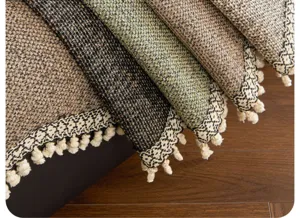 Gros plan détaillé de la housse de canapé tissée texturée avec bordure à franges géométriques.