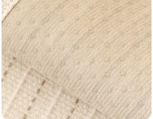 Close-up van beige antislip bankkussen stoftextuur met siliconen stippen erop.