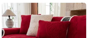Detail shot of red textured leaf sofa cover with soft plush pillows in a cozy living room.
