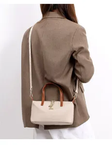 Detail view of the mini nylon crossbody bag with brown handles and chain decoration.
