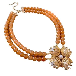 Collar vintage de doble hebra de cuentas naranjas con colgante de flor dorada y perla.