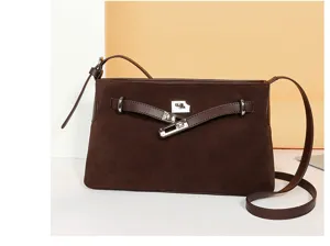 Brown suede shoulder bag closeup, stylish commuter crossbody handbag with metal lock hardware details.