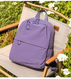 Casual purple backpack displayed on an outdoor camping chair in a green garden setting.