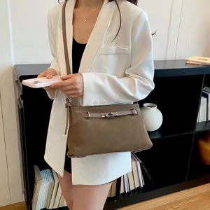 Chic brown suede shoulder crossbody bag for women, elegant commuting tote with metal lock.