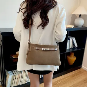 Brown suede shoulder bag for women, stylish crossbody handbag with metal lock and slim strap.