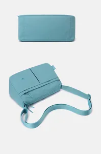 Light blue multi-layer nylon crossbody bag detail view with adjustable strap and pockets.