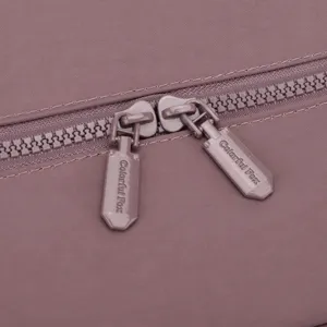 Close-up detail shot of the durable double zipper and pullers on the stylish travel backpack.