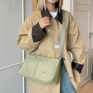 Casual multi-layer crossbody bag for women, lightweight nylon shoulder bag with wide strap.
