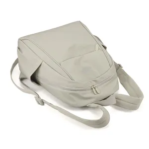 Detailed view of the light grey nylon backpack with front pocket and durable dual shoulder straps.