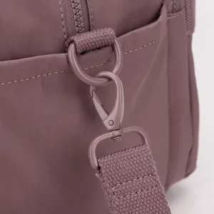 Detailed view of purple gym bag shoulder strap metal hook and D-ring, durable hardware.