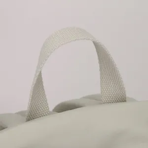 Backpack detail view showing the durable woven top handle and padded nylon fabric structure.