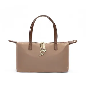 Nylon shoulder bag detail shot, khaki fabric with brown handles and chic gold chain pendant.