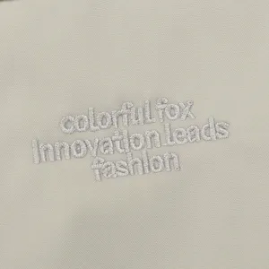 Close-up of durable nylon backpack fabric featuring neat embroidery detail and stylish text design.