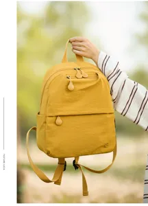 Casual yellow backpack for women, compact design with multiple zipped pockets for daily commute.