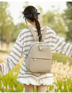 Detailed view of the casual beige travel backpack worn outdoors, lightweight daily.