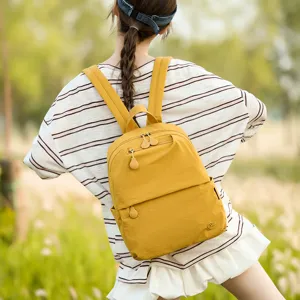 Casual yellow backpack for women, lightweight daily school travel daypack with zipper pockets.