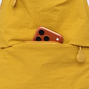 Close-up detail of the yellow casual backpack front zipper pocket showing daily use.