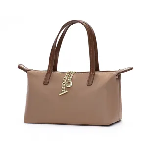 Waterproof nylon mini shoulder bag with brown leather handles and chic gold chain detail.