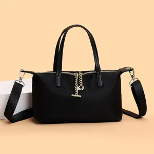 Black nylon handbag with shoulder strap, minimalist design, stylish detail for daily wear.