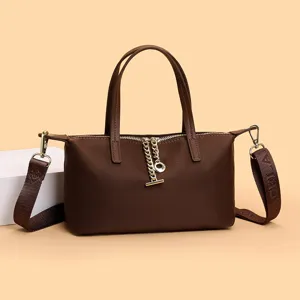 Brown nylon mini handbag, stylish crossbody bag with top handles, metal chain zipper detail.