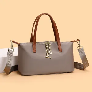 Niche design nylon crossbody bag detail, featuring metal chain zipper and brown top handles.