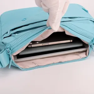 Light blue multi-layer crossbody bag detail showing spacious interior capacity and zipper pockets.