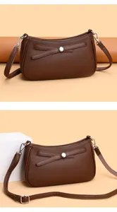 Detailed view of a stylish brown leather crossbody bag with chic bow accent, perfect for daily use.