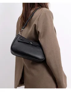 Detailed view of women's black textured leather shoulder bag with chic metal hardware.