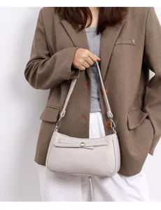 Minimalist leather shoulder bag detail, stylish crossbody handbag with elegant bow accent.