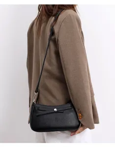 Minimalist black shoulder bag for women, stylish crossbody handbag with bow and metallic clasp.
