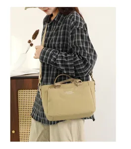 Détail du sac bandoulière en nylon avec poches multiples et bandoulière réglable.