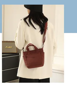Vue détaillée du sac bandoulière léger en nylon avec poche avant et poignée pratique.