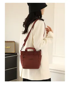 Vue détaillée du sac bandoulière en nylon léger, pratique avec anses et bandoulière.