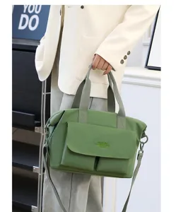 Sac cabas bandoulière en nylon vert léger avec double poignée et poche avant pratique.