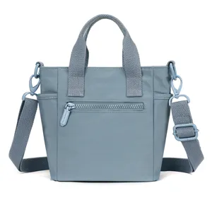 Gros plan du sac bandoulière en nylon bleu avec poche zippée sécurisée et sangle solide.