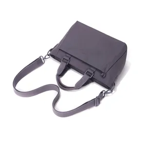 Détail de sac bandoulière en nylon montrant une sangle réglable et un tissu résistant.