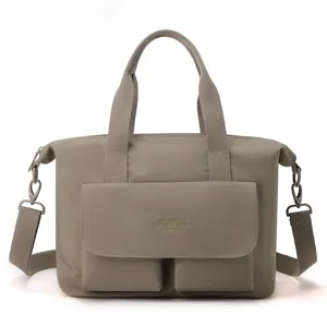Vue détaillée du grand sac cabas en nylon, sac bandoulière décontracté avec poches avant.
