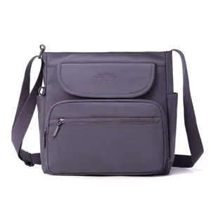 Greyish purple nylon crossbody bag detail, multi-pocket design with adjustable strap.