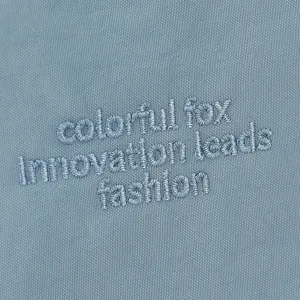 Vue rapprochée du tissu en nylon bleu résistant à l'eau montrant des détails de broderie.