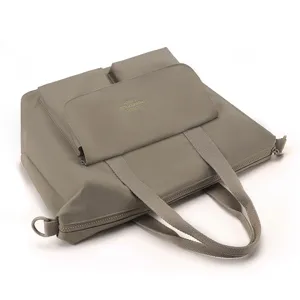Sac cabas en nylon gris vue détaillée montrant la conception multi-poches et le tissu résistant.