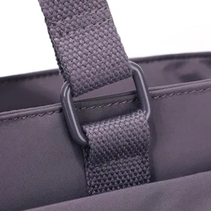 Vue détaillée du connecteur de sangle de sac bandoulière en nylon violet et tissu.