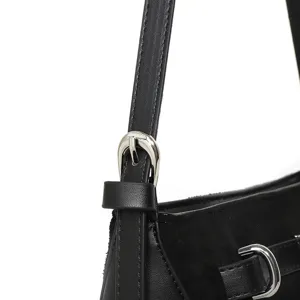 Detailed close-up view of women's black shoulder bag strap and silver buckle hardware.