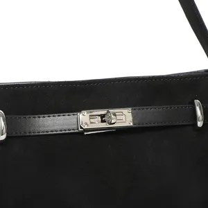 Close-up detail of black suede tote bag featuring metallic turn-lock closure and leather strap.
