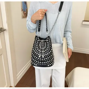 Black studded bucket bag with chain strap, stylish punk style fashion leather shoulder bag.