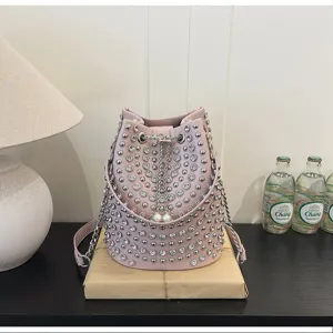 Pink studded bucket bag with rhinestones, chain strap, and pearl drawstring closure.