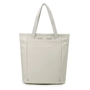 Minimalist light grey nylon tote bag, featuring sturdy dual handles and clean front pocket details.
