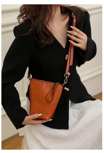 Stylish brown leather bucket handbag, minimalist design, perfect for daily wear and commuting.
